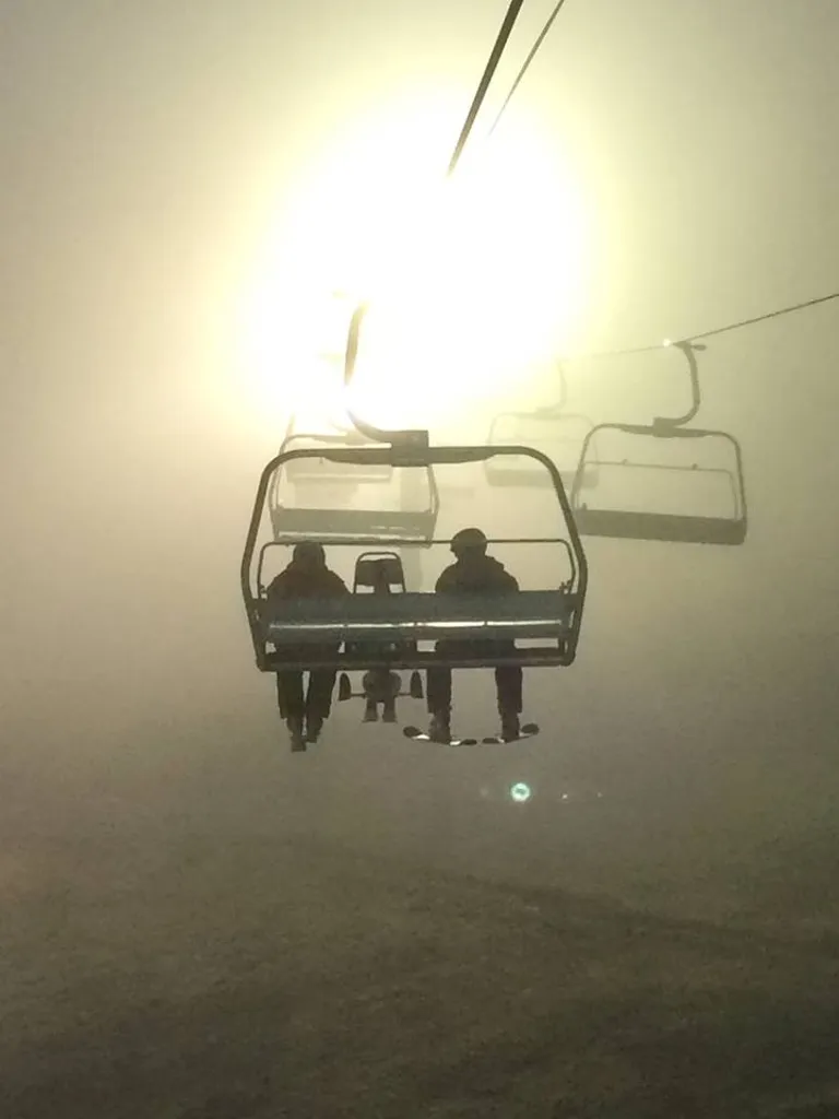 Adaptive skier descending a snowy Alaskan slope at sunset